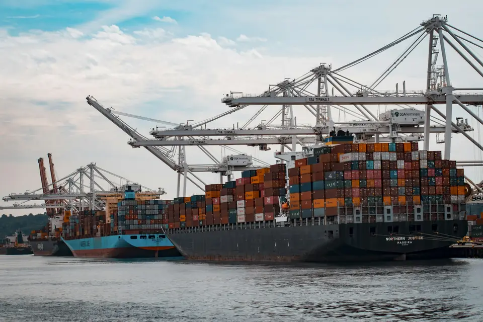 Container ship being loaded under port cranes